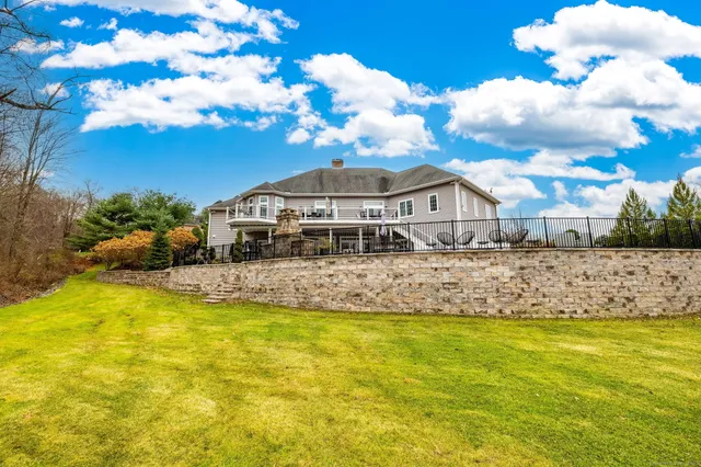 a view of a swimming pool with an outdoor seating and house in the background