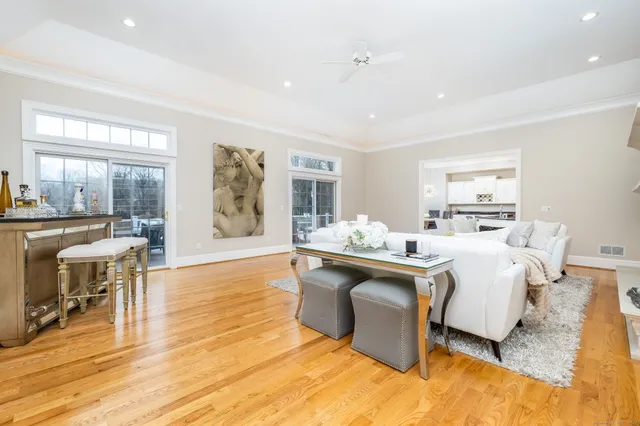 a living room with stainless steel appliances granite countertop furniture wooden floor and a large window