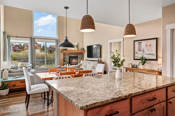 a dining room with wooden floor a chandelier a wooden table and chairs
