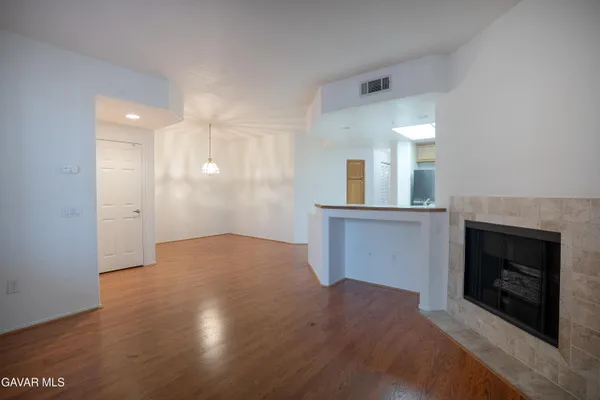 a view of a kitchen with wooden floor and a window