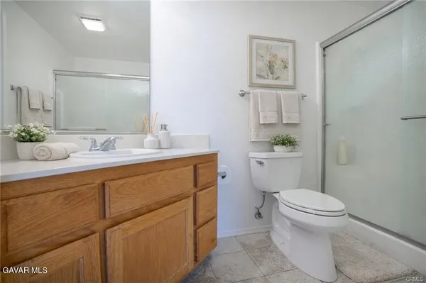 a bathroom with a granite countertop toilet sink and mirror
