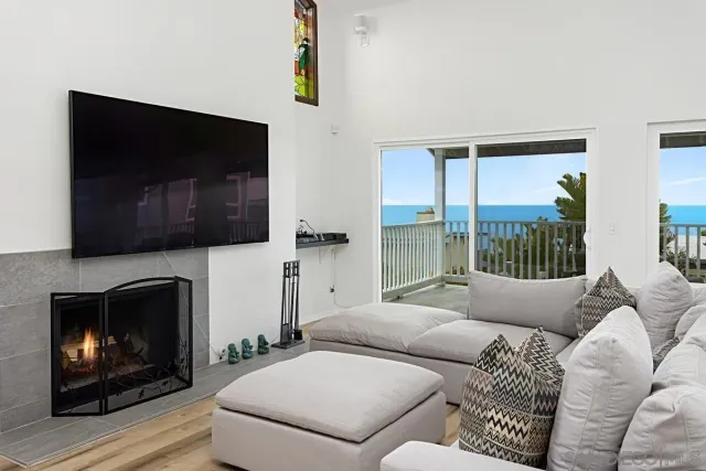 a living room with furniture a flat screen tv and a fireplace