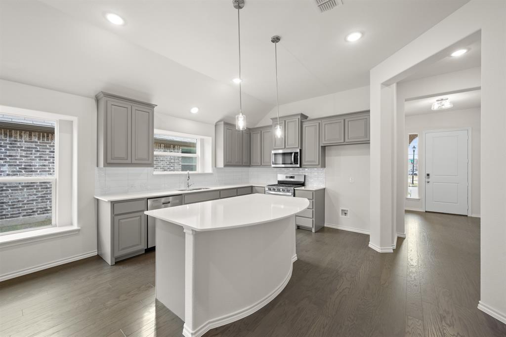 810 Misty Lane Cleburne, TX 76033 - Photo 4 of 30 a large kitchen with stainless steel appliances kitchen island a large counter top and a wooden floors