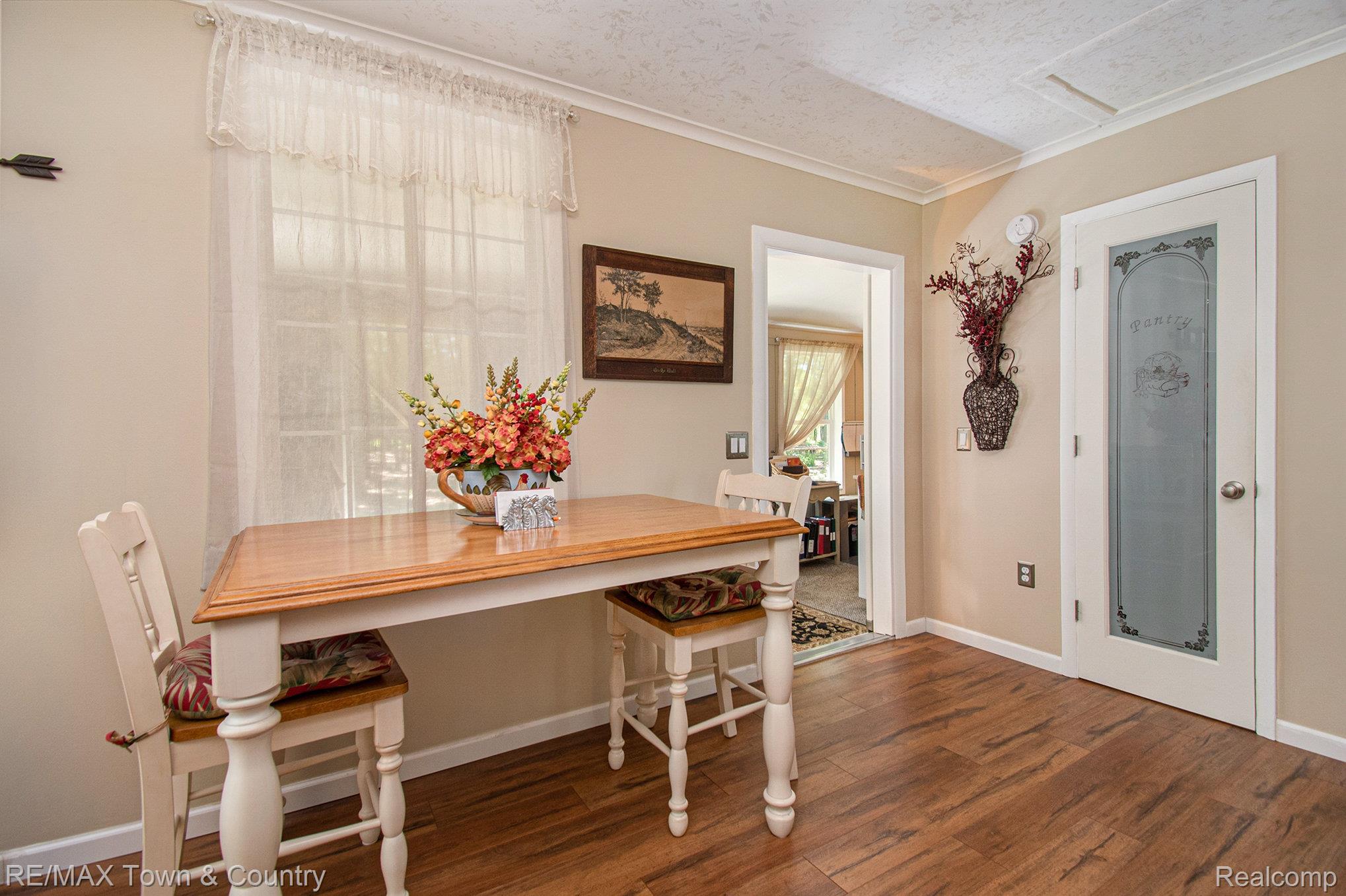 1293 Bellinger Road Gladwin, MI 48624 - Photo 9 of 27 Wood-finish flooring with neutral wall tones and white crown molding