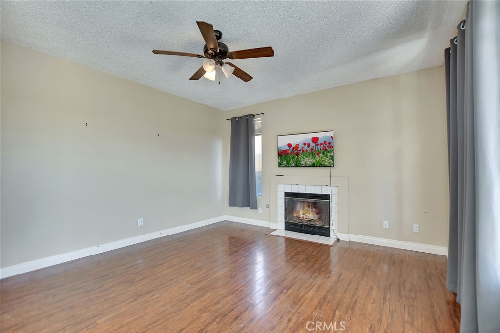14527 Pony Trail Road Victorville, CA 92392 - Photo 15 of 21 a view of an empty room with wooden floor fireplace and a window