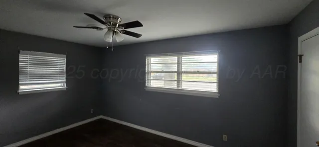 an empty room with a window and a fan