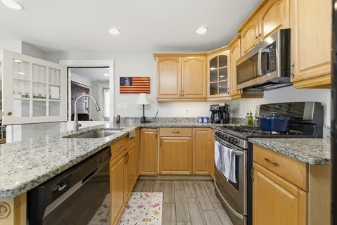 a kitchen with stainless steel appliances granite countertop a sink stove and cabinets