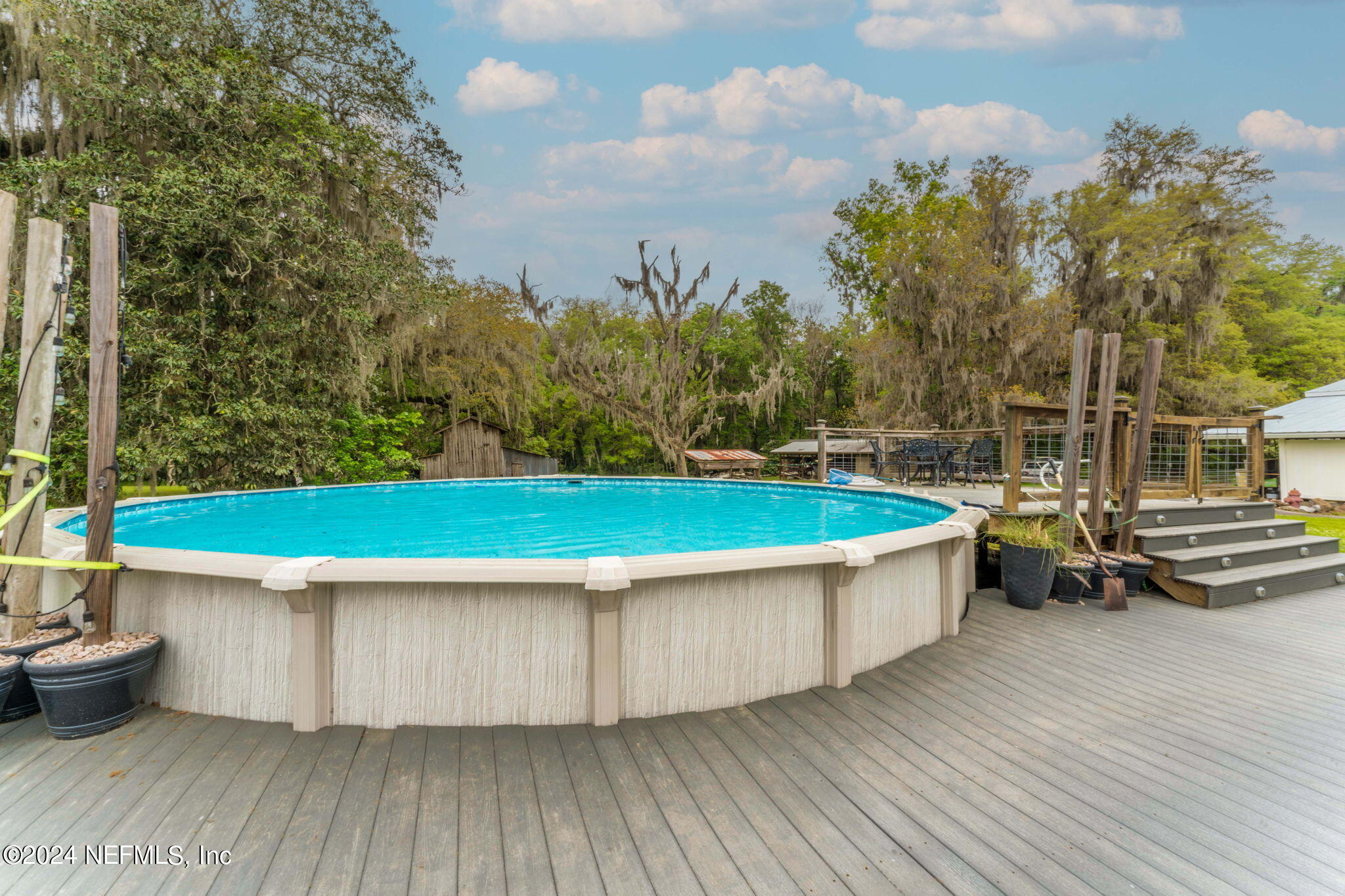 542284 Lem Turner Road Callahan, FL 32011 - Photo 54 of 84 a view of a swimming pool with a bench and trees around