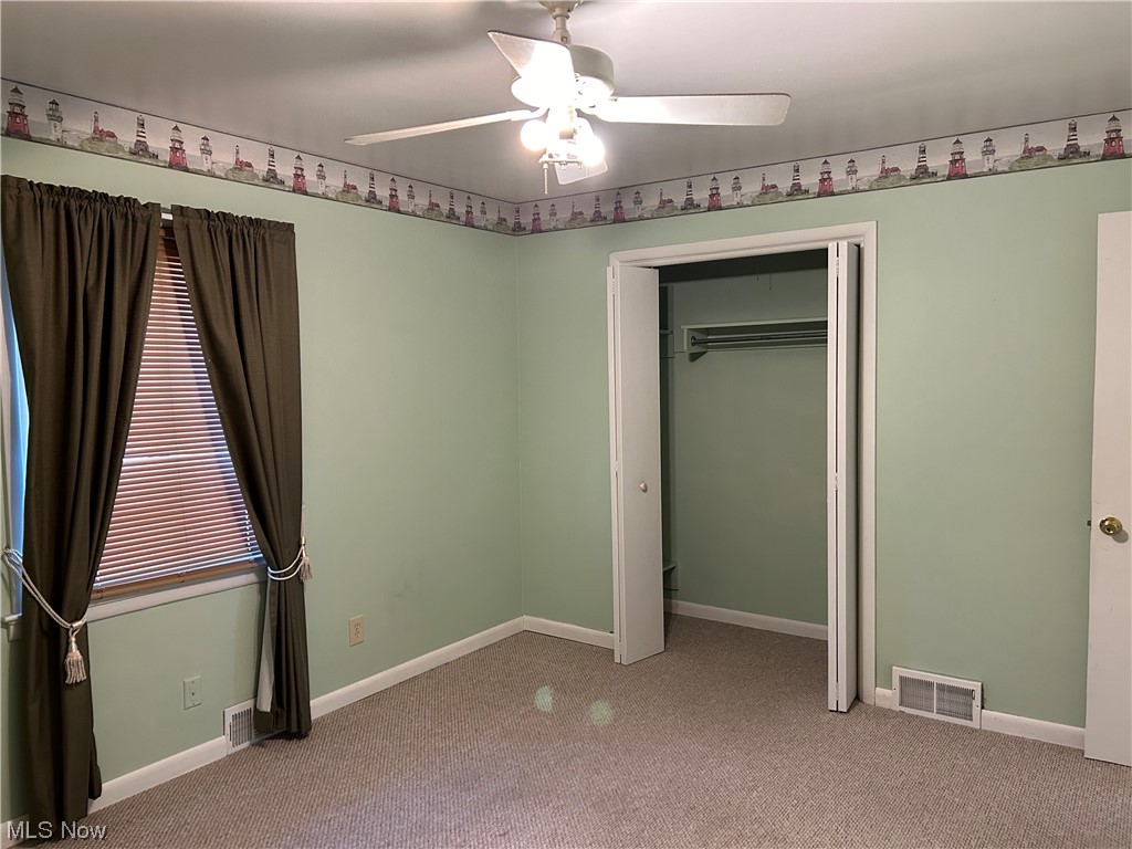 766 Bridge Road Akron, OH 44312 - Photo 16 of 34 First floor bedroom with ceiling fan, light colored carpet, and a nice closet