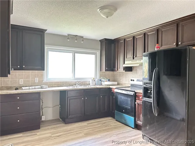 a kitchen with a sink a window and stainless steel appliances
