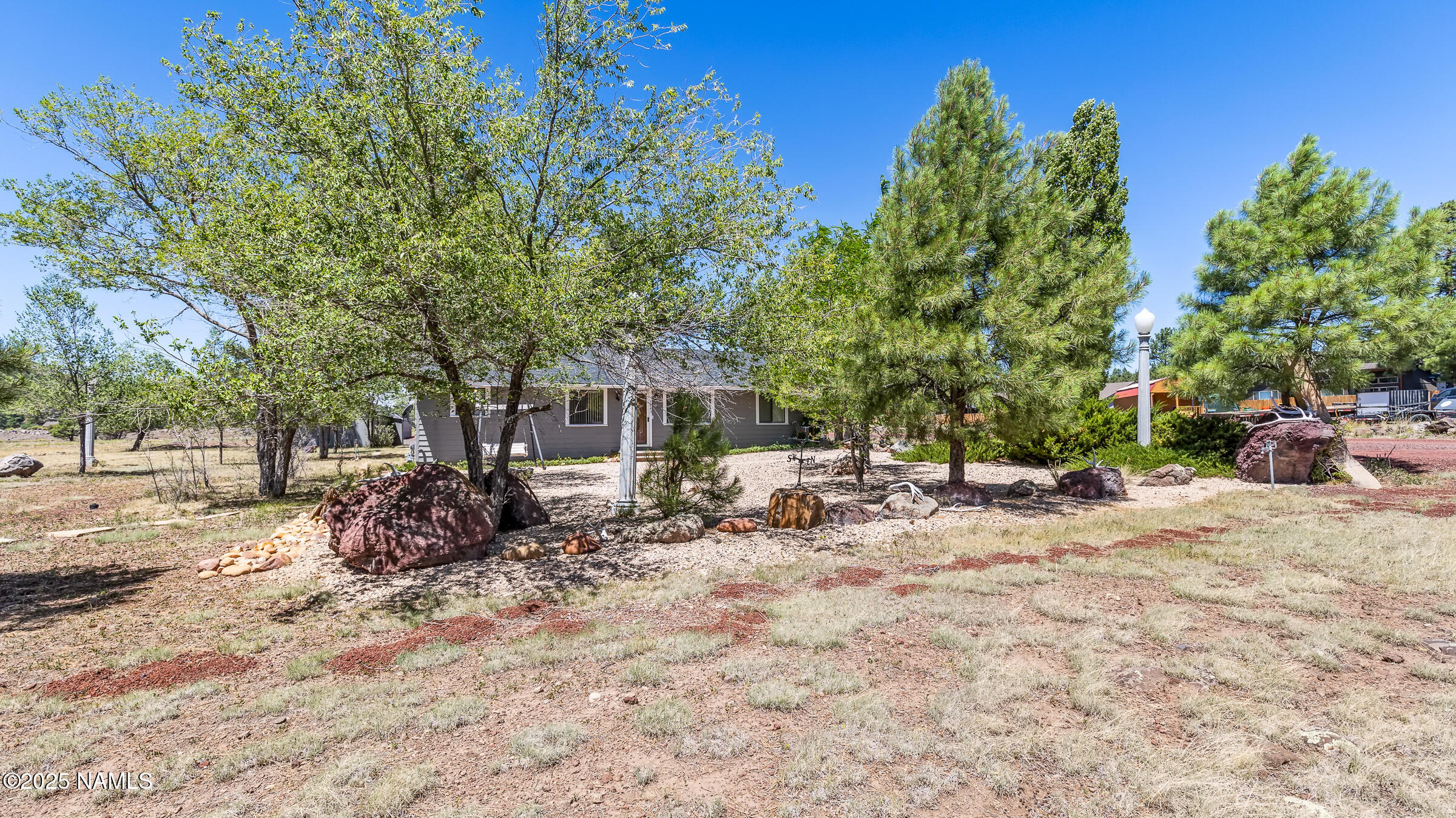 1843 Country Club Road Williams, AZ 86046 - Photo 35 of 36 a backyard of a house with table and chairs and a large tree