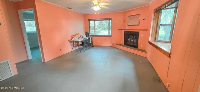 a view of empty room with window and fireplace