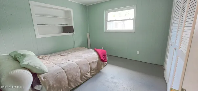 a bedroom with a bed and a window