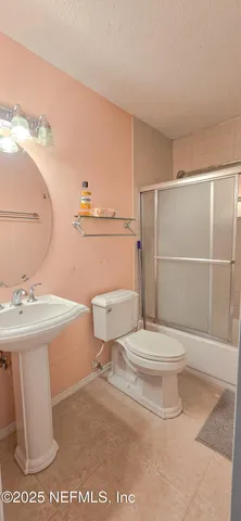 a bathroom with a toilet a sink and a mirror