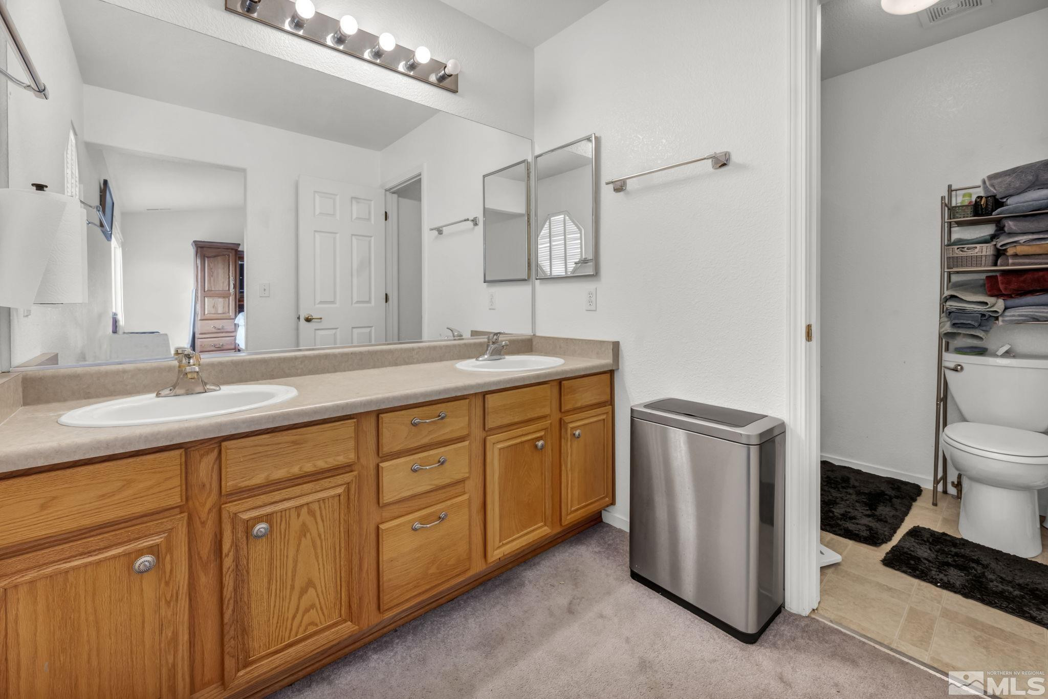 17795 Oakview Court Reno, NV 89508 - Photo 13 of 34 a spacious bathroom with a granite countertop sink a toilet a mirror and shower