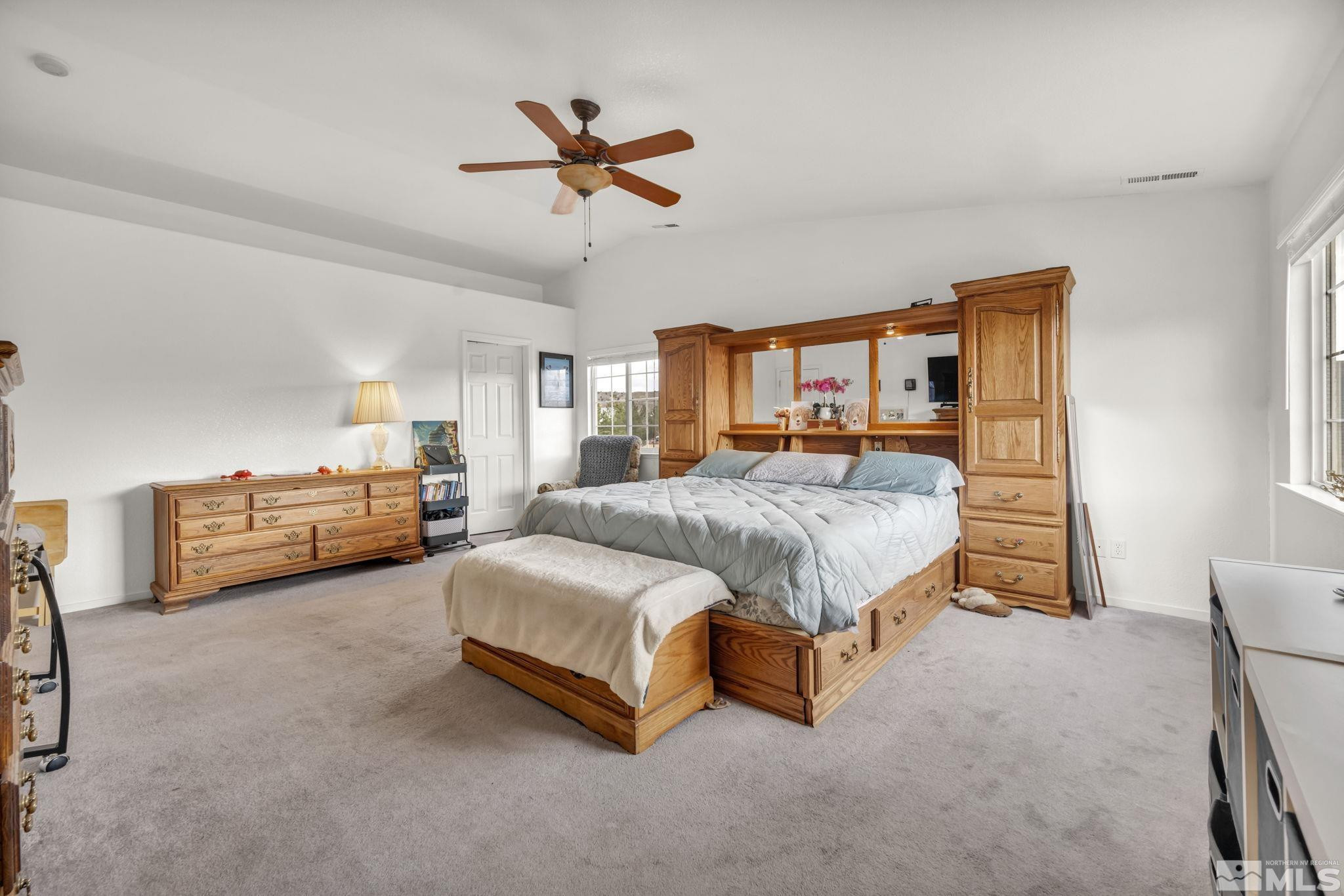 17795 Oakview Court Reno, NV 89508 - Photo 15 of 34 a spacious bedroom with a bed a couch and a chandelier