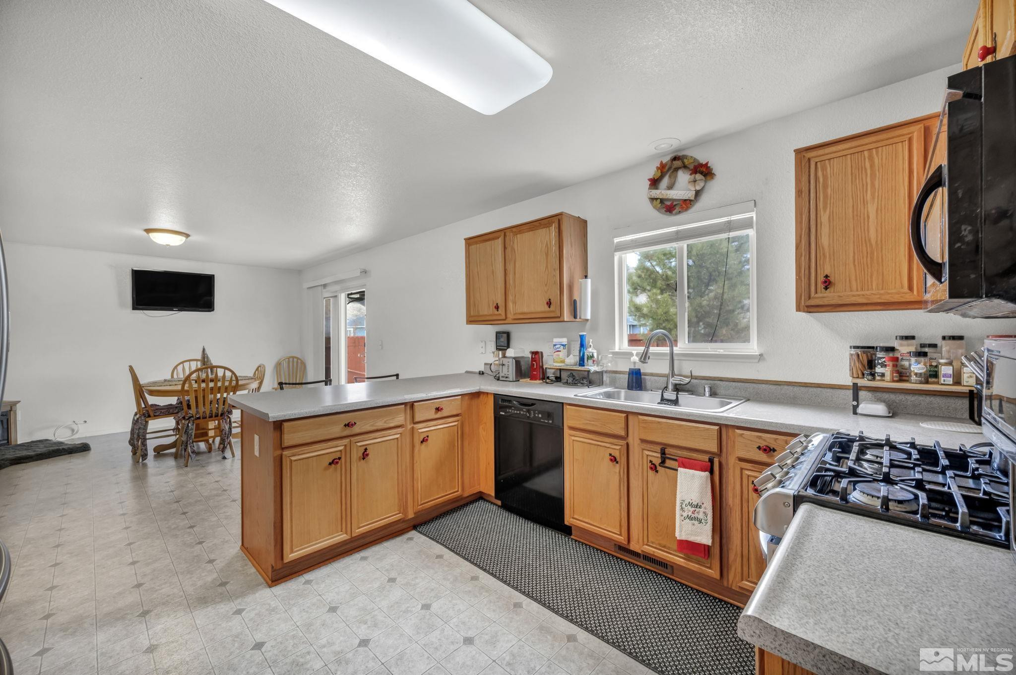 17795 Oakview Court Reno, NV 89508 - Photo 6 of 34 a kitchen with stainless steel appliances a stove a sink cabinets and a window