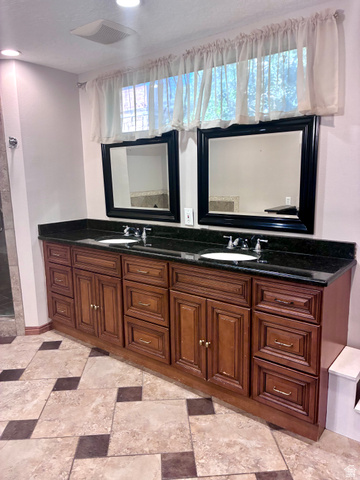 1903 Ridgehollow Drive Bountiful, UT 84010 - Photo 12 of 24 Dual vanity featuring dark wood cabinetry, black countertops, and two undermount sinks