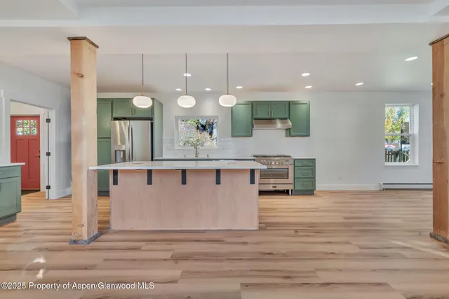 an open kitchen with granite countertop a sink and a wooden floor