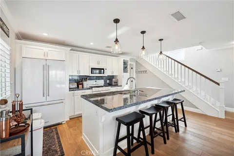 a large white kitchen with a large window and stainless steel appliances