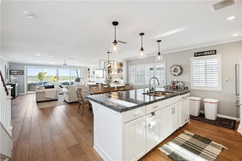 a kitchen with granite countertop a sink a stove and cabinets