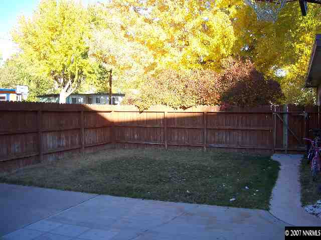 1685 Jackson Place Reno, NV 89512 - Photo 7 of 9 a view of a backyard with wooden fence and large trees