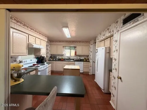 a kitchen with stainless steel appliances granite countertop a refrigerator and a stove