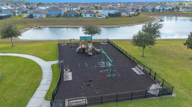 an aerial view of a house with a yard and lake view