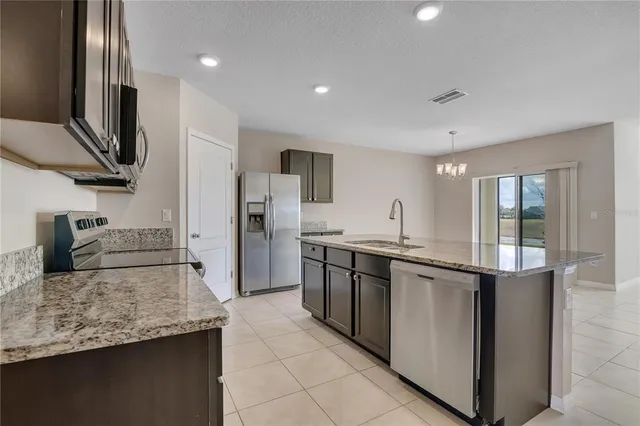 a living room with stainless steel appliances furniture a fireplace and a flat screen tv