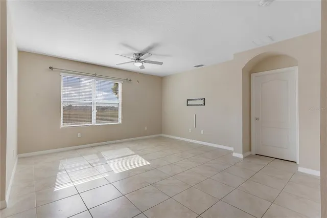 an empty room with a windows and chandelier