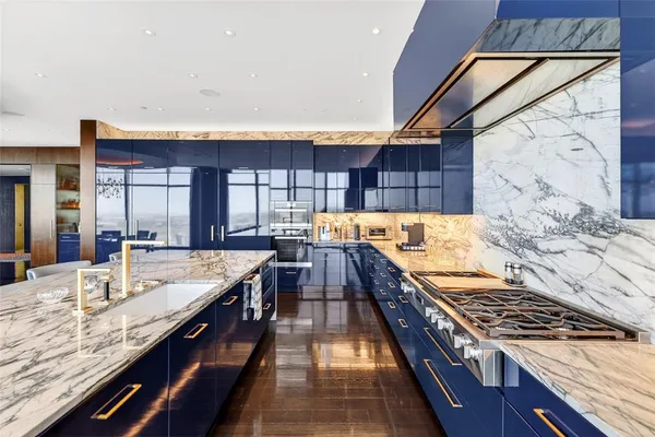 a large kitchen with granite countertop lots of counter top space and stainless steel appliances