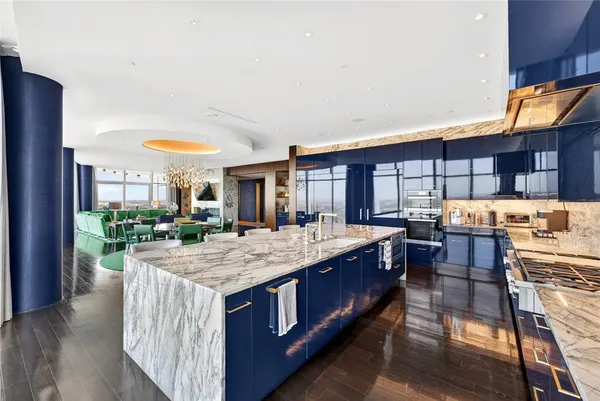 a kitchen with kitchen island granite countertop a stove and a wooden floors