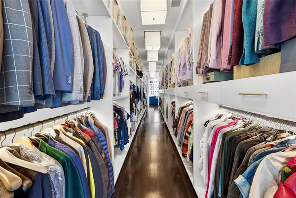 a view of walk in closet with clothes and shoes