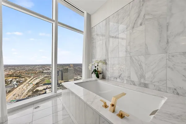 a bathroom with a tub and a large window