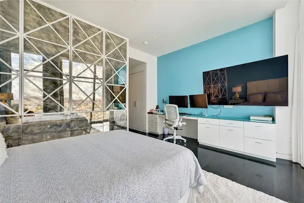 a bedroom with a bed and a flat screen tv