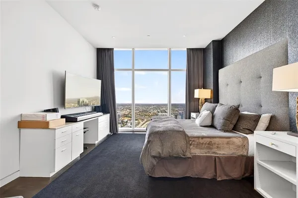 a bedroom with a bed and large windows