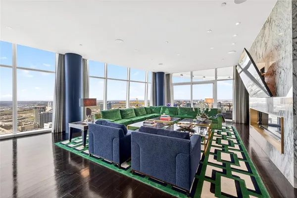 a living room with furniture floor to ceiling window and wooden floor