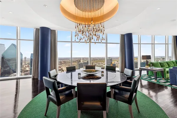 a dining room with furniture a chandelier and wooden floor