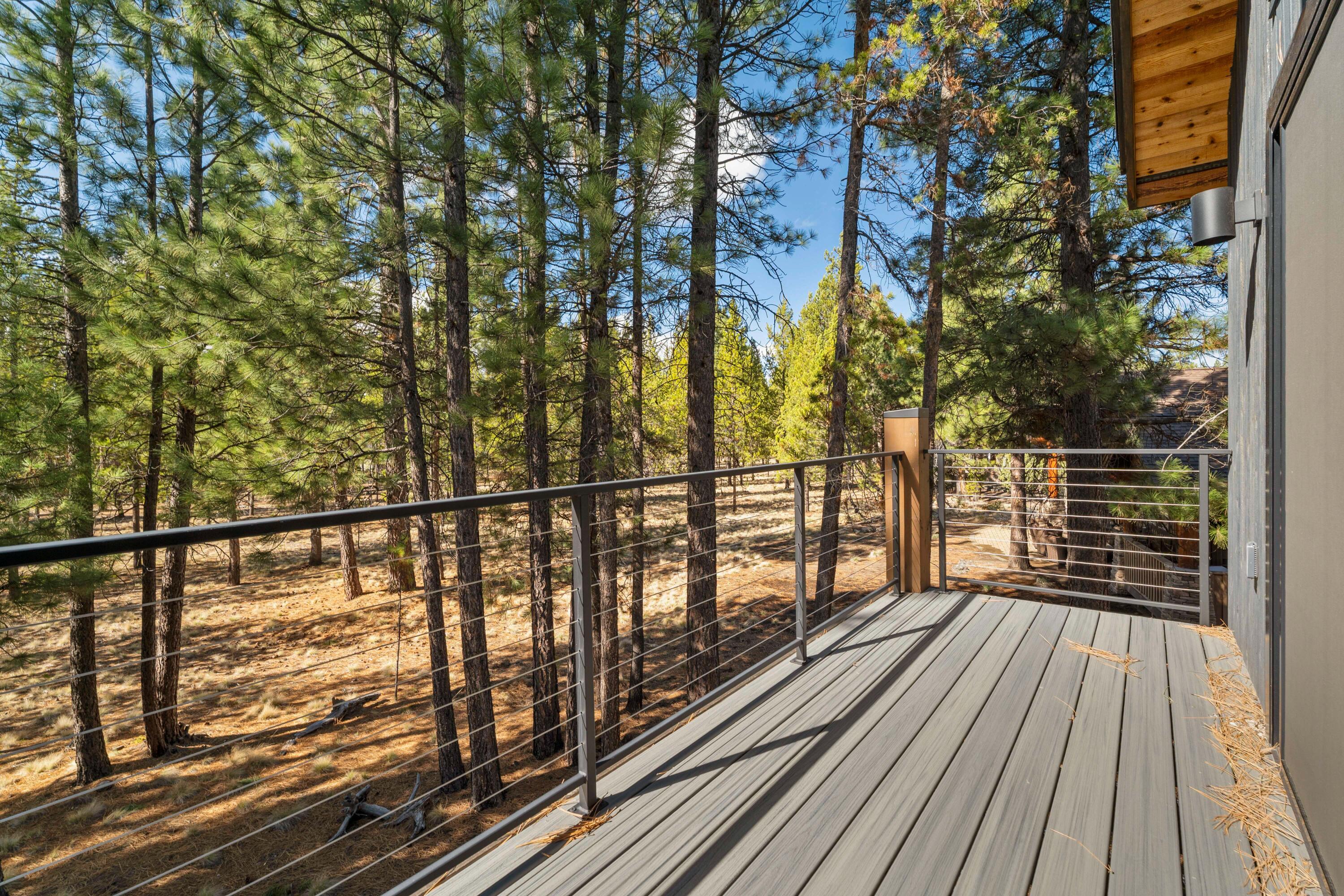 56670 Sunstone Loop, Unit LOT 141 Bend, OR 97707 - Photo 19 of 62 Private upper deck with cable railing, composite-style decking, and tranquil outlooks across the greenbelt and pine canopy.