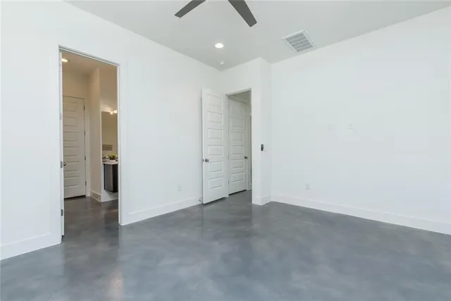 an empty room with closet and a chandelier fan