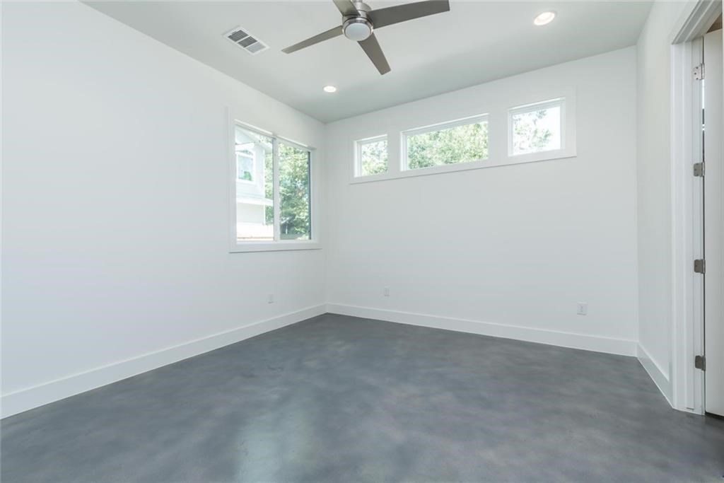1403 Arcadia Avenue, Unit A Austin, TX 78757 - Photo 14 of 35 an empty room with windows and fan
