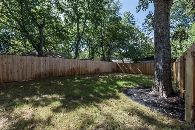 a view of garden with wooden fence