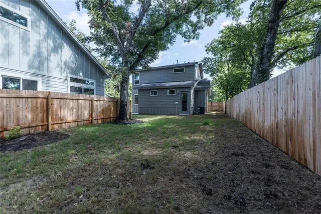 a view of a house with backyard and tree