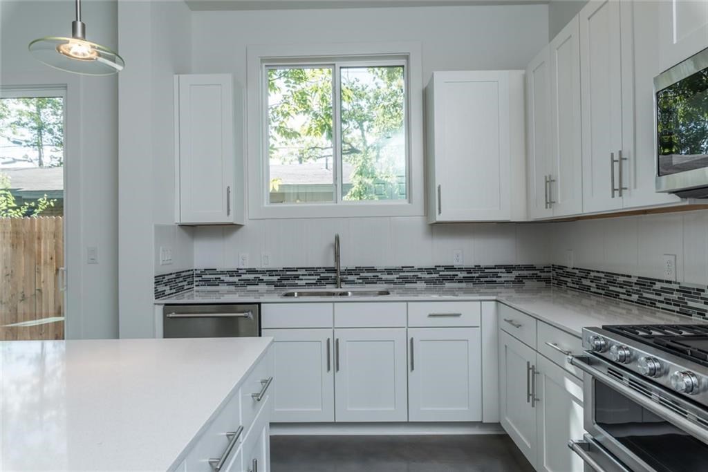 1403 Arcadia Avenue, Unit A Austin, TX 78757 - Photo 9 of 35 a kitchen with granite countertop white cabinets and appliances