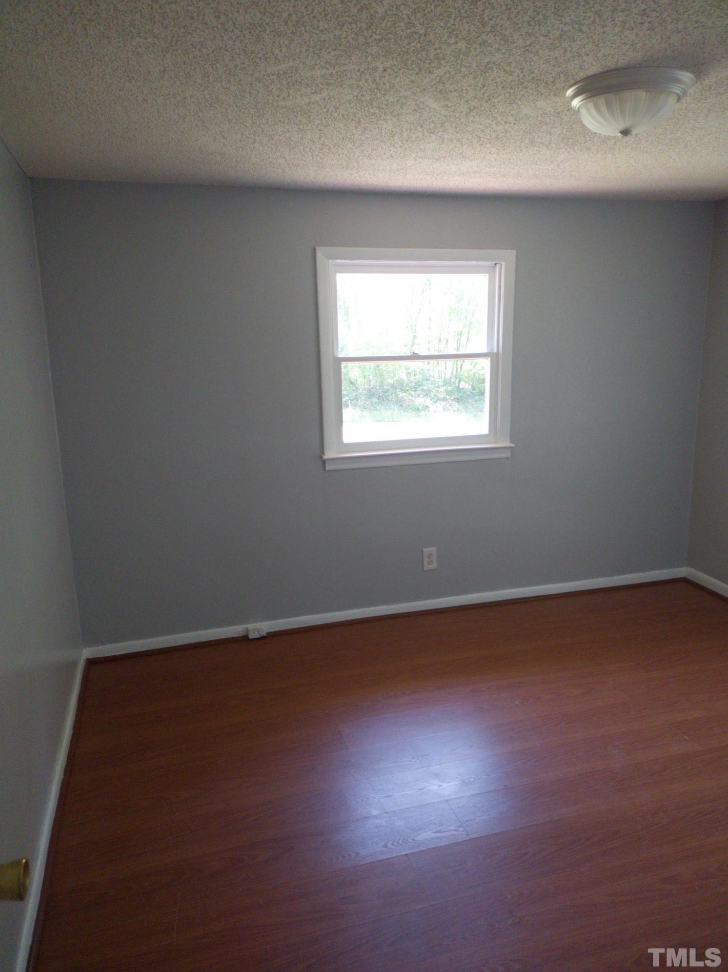 563 Williams Road Spring Hope, NC 27882 - Photo 12 of 16 an empty room with wooden floor and windows