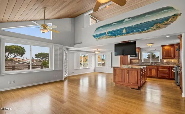 a view of a kitchen with furniture a chandelier and wooden floor