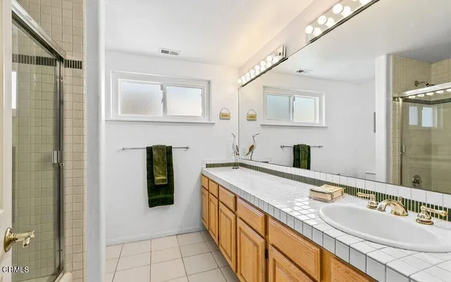 a spacious bathroom with a granite countertop sink and a mirror