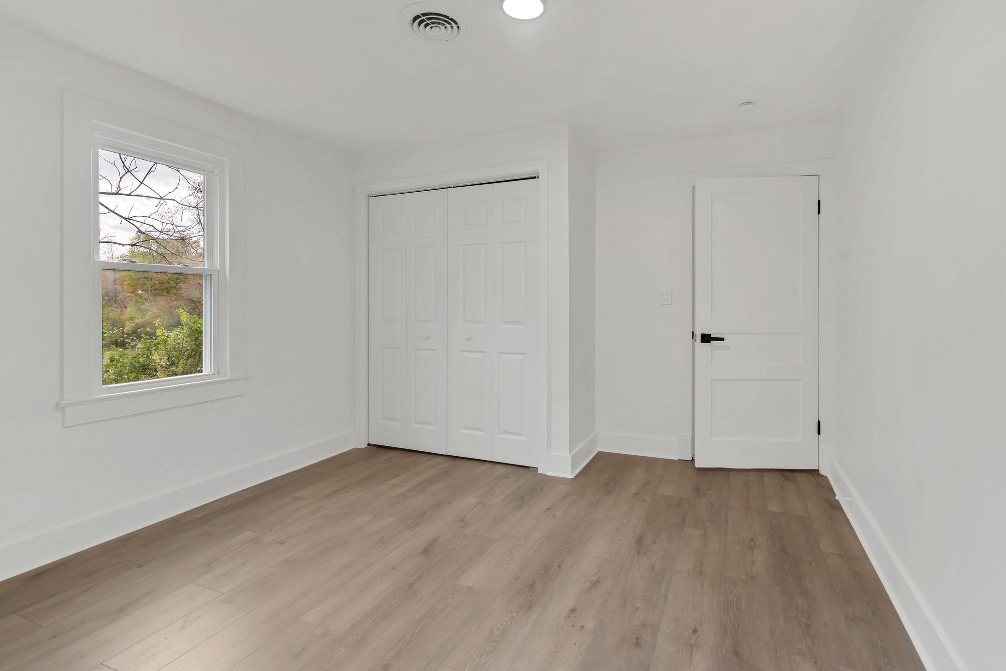 5060 Drakes Branch Road Nashville, TN 37218 - Photo 20 of 43 a view of an empty room with wooden floor and a window