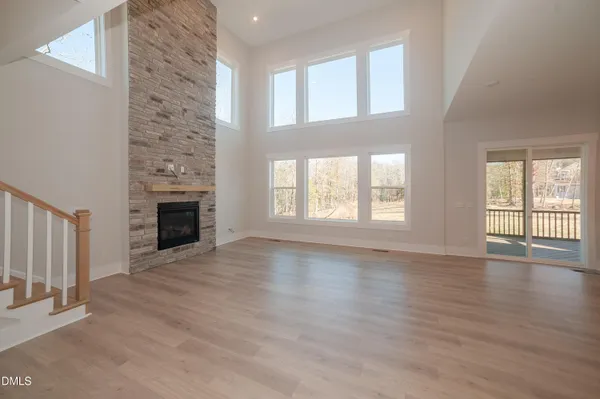 a view of empty room with wooden floor and fireplace