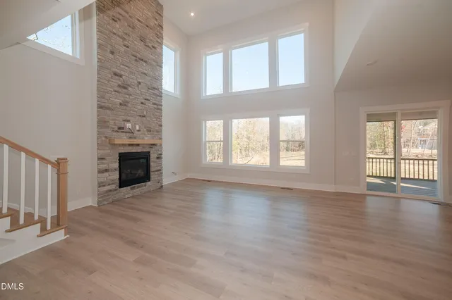a view of empty room with wooden floor and fireplace
